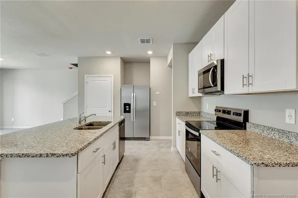 a large kitchen with granite countertop a stove and a sink