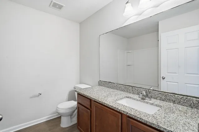 a bathroom with a granite countertop sink and a mirror