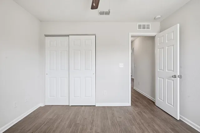 a view of an empty room with wooden floor