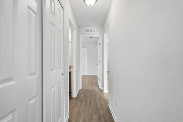 a view of a hallway with wooden floor