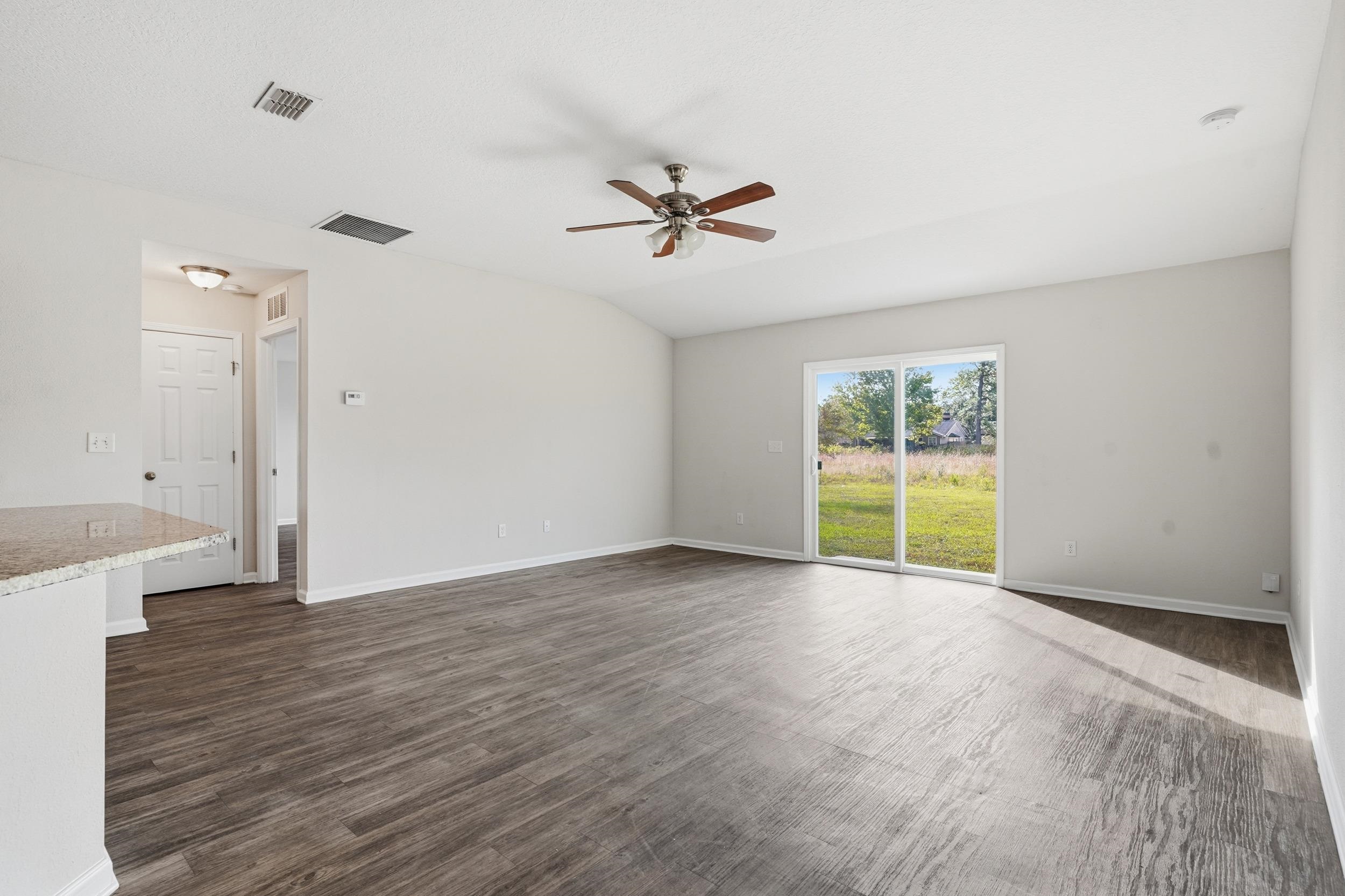 8772 Kaye Lane Jacksonville, FL 32244 - Photo 3 of 35 Empty room featuring dark wood-type flooring, ceiling fan, and lofted ceiling