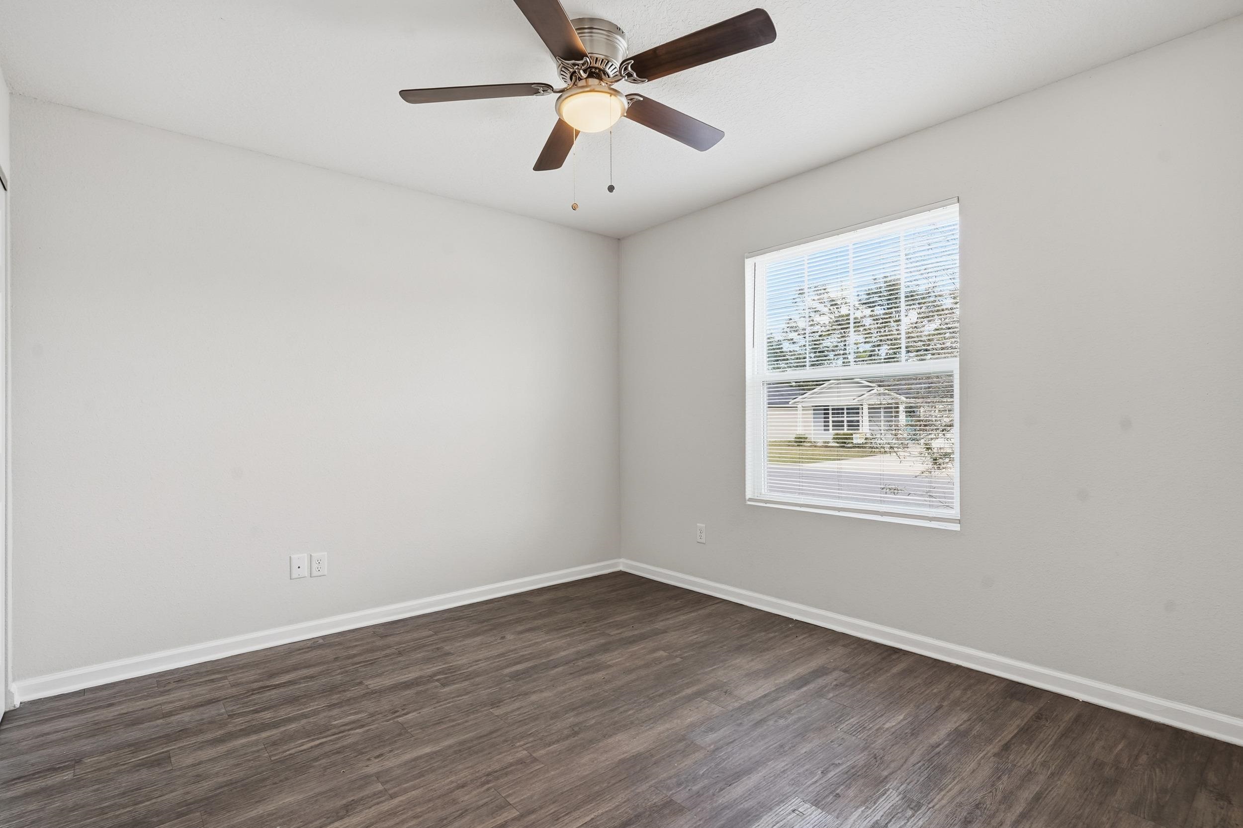 8772 Kaye Lane Jacksonville, FL 32244 - Photo 5 of 35 Spare room featuring dark wood-style flooring and a ceiling fan