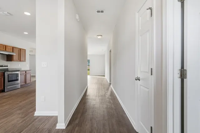 a view of a hallway with wooden floor and staircase