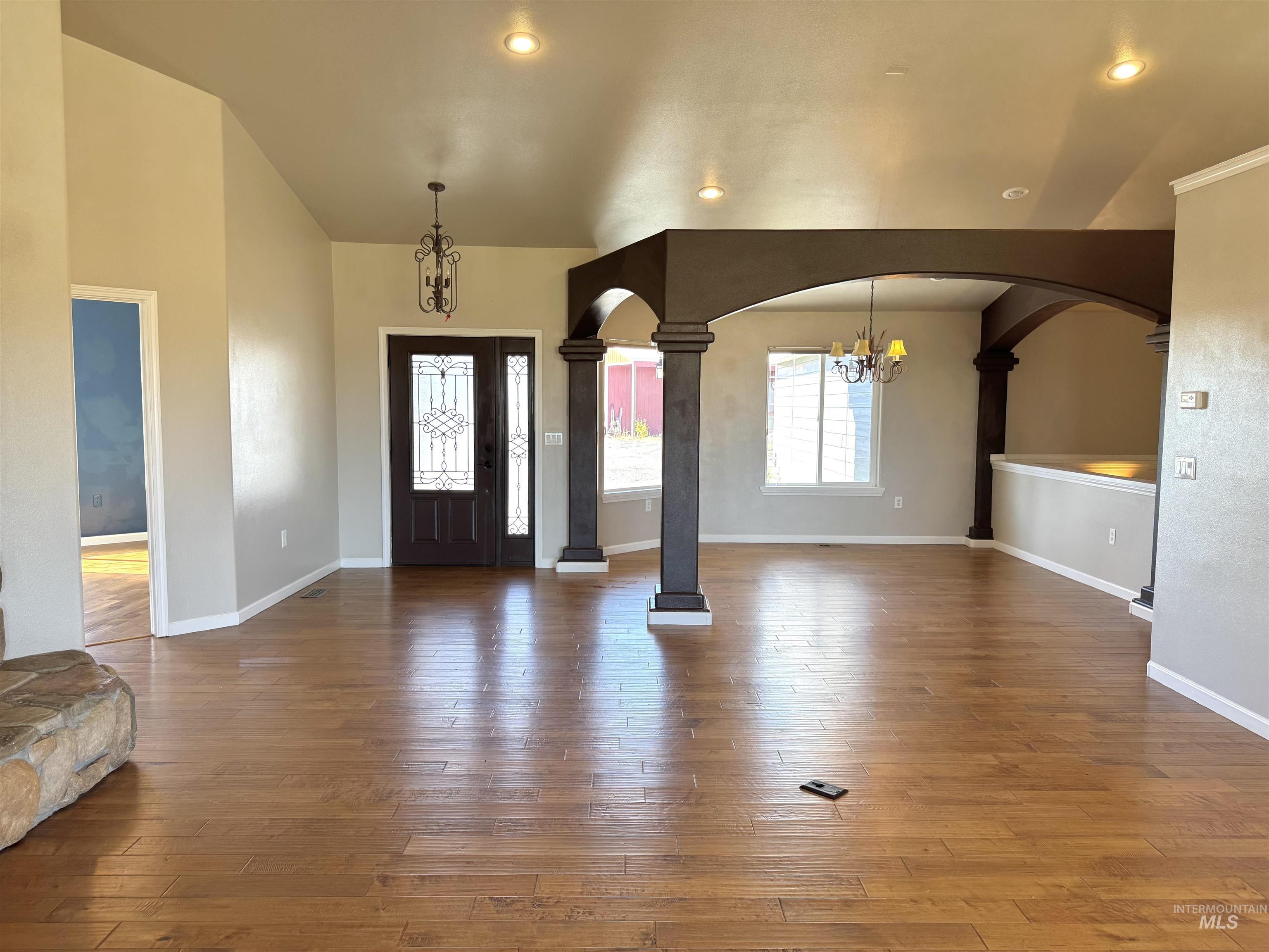 1030 Reams Road Moscow, ID 83843 - Photo 17 of 50 Entryway with a chandelier, dark wood-style floors, arched walkways, ornate columns, and recessed lighting