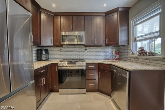 a kitchen with stainless steel appliances granite countertop a sink stove and microwave