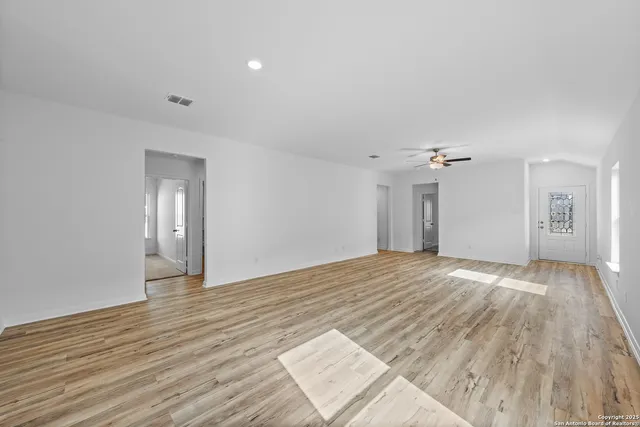 a view of empty room with wooden floor