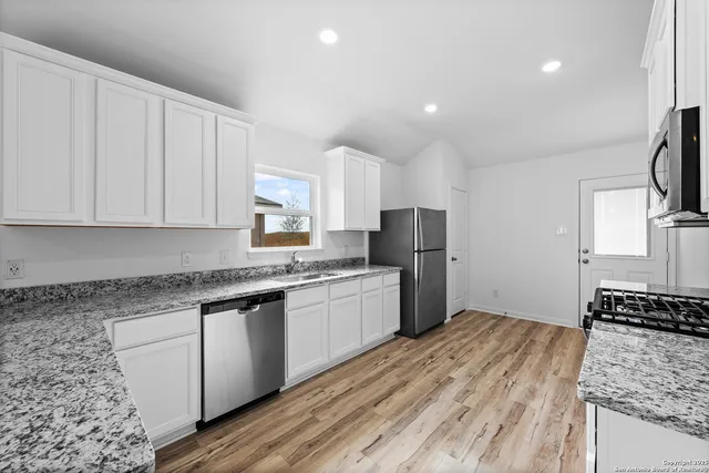 a kitchen with stainless steel appliances granite countertop a stove a sink and a refrigerator