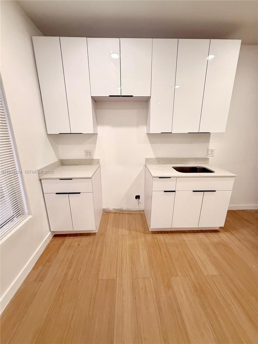 125 Southwest 19th Avenue, Unit 2 Miami, FL 33135 - Photo 2 of 8 a room with wooden floor and cabinets