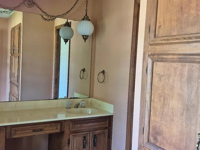 a bathroom with a granite countertop sink and a mirror