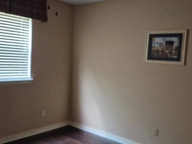 a view of a small space with wooden floor and a window