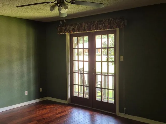 an empty room with wooden floor and windows