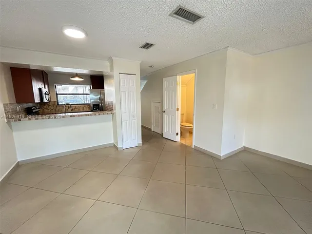 a view of a kitchen with a sink and a refrigerator