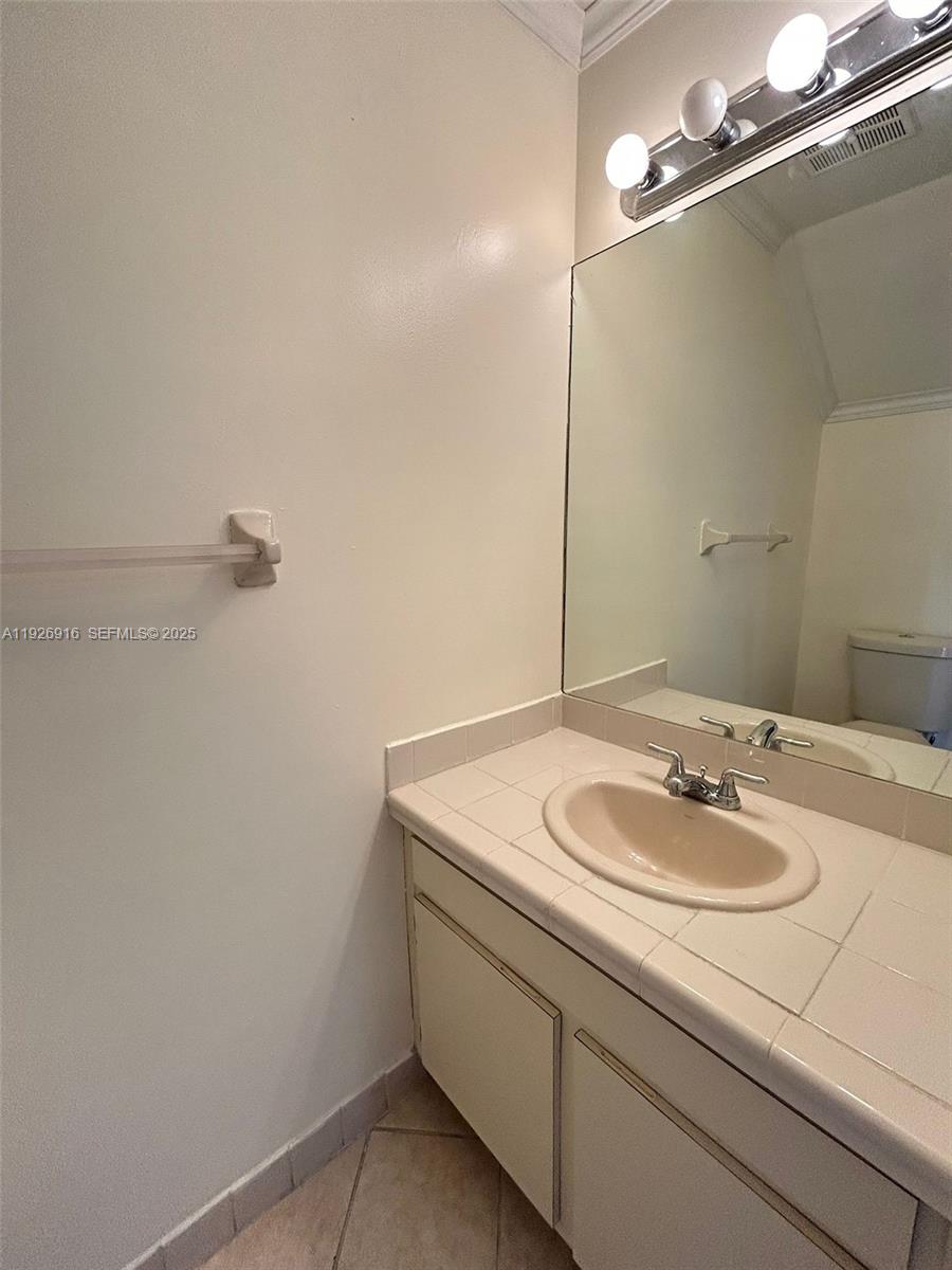 13444 Southwest 62nd Street, Unit 104F Miami, FL 33183 - Photo 24 of 40 a bathroom with a sink and a mirror