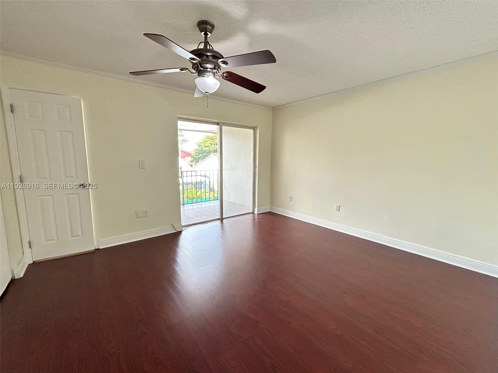 13444 Southwest 62nd Street, Unit 104F Miami, FL 33183 - Photo 26 of 40 an empty room with wooden floor fan and windows