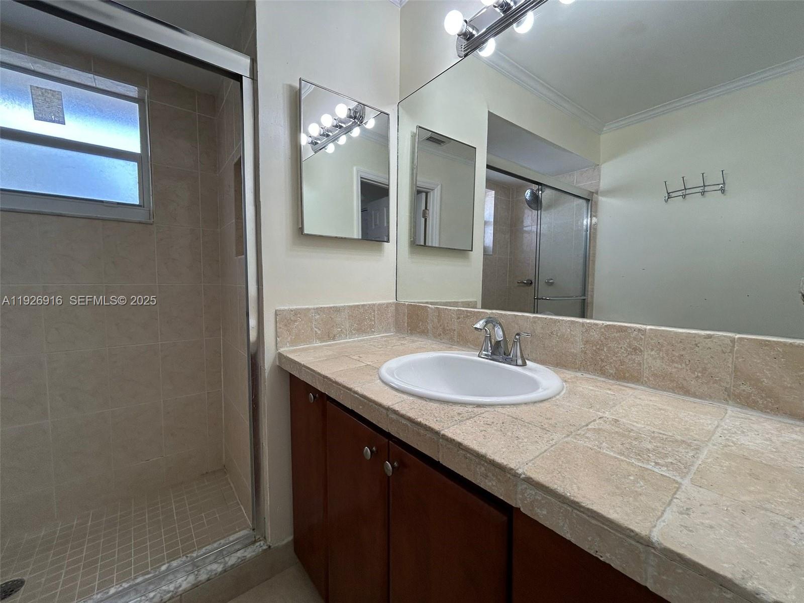 13444 Southwest 62nd Street, Unit 104F Miami, FL 33183 - Photo 34 of 40 a bathroom with a sink and a mirror