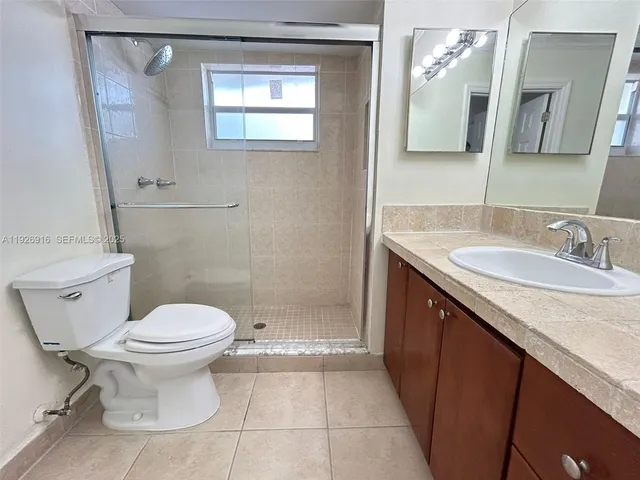 an empty room with a mirror and a ceiling fan