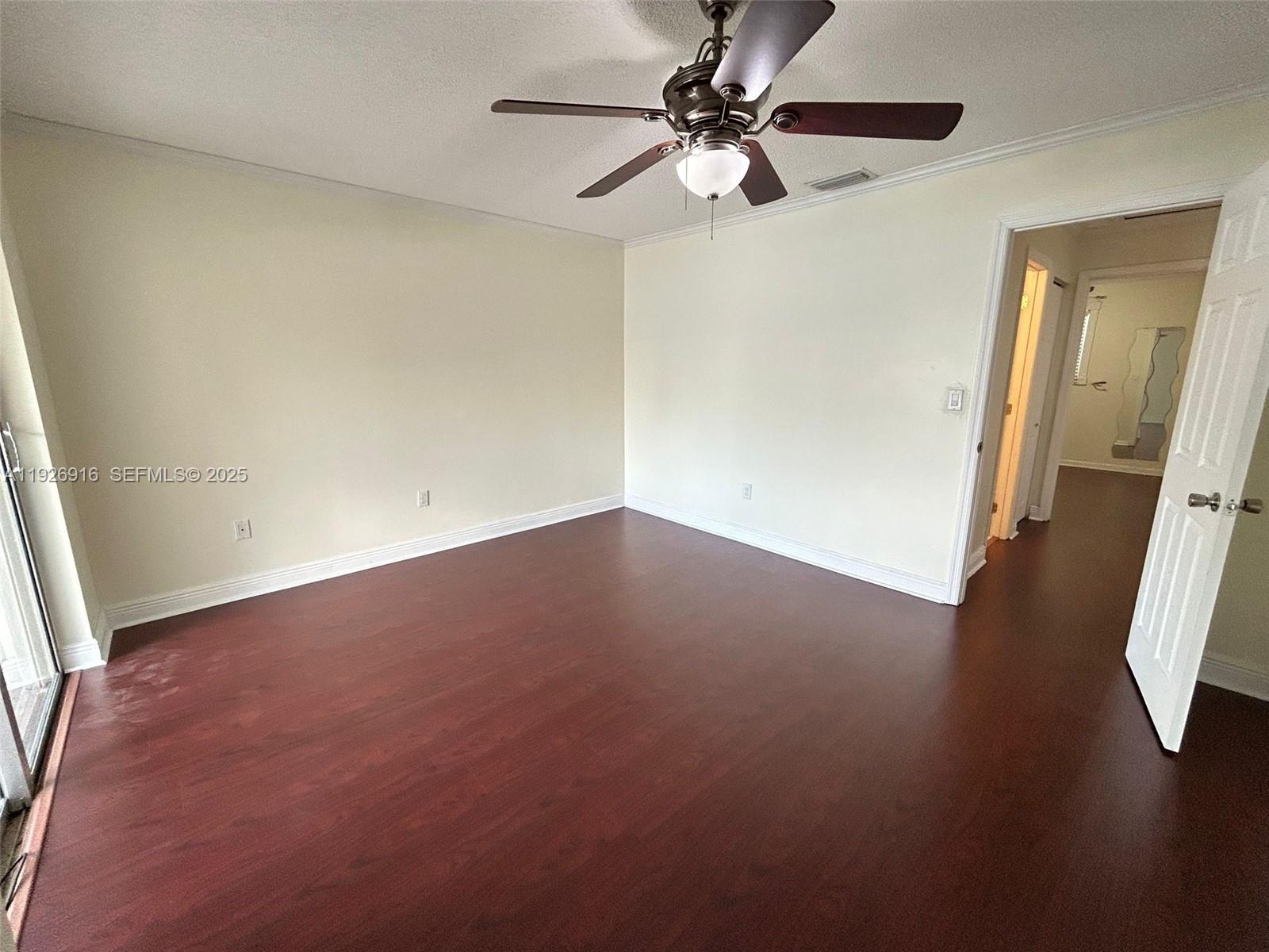 13444 Southwest 62nd Street, Unit 104F Miami, FL 33183 - Photo 36 of 40 an empty room with a mirror and a ceiling fan