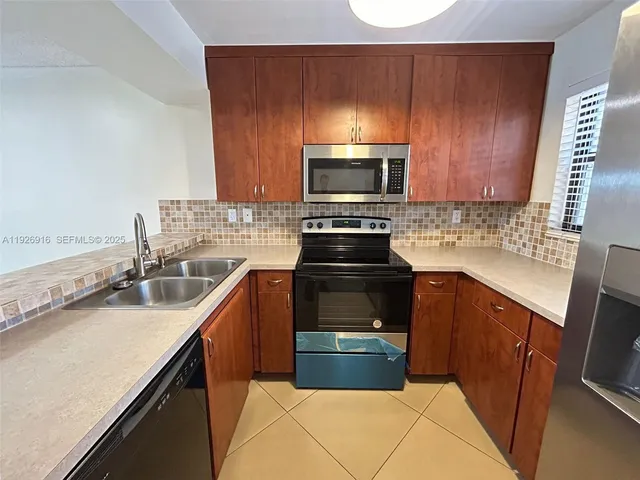 a kitchen with granite countertop a sink stove and microwave