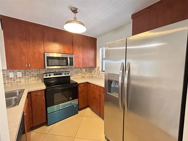 a kitchen with wooden cabinets and stainless steel appliances