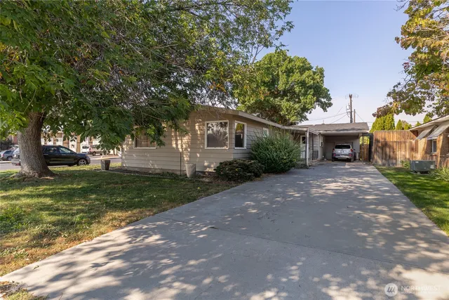 a front view of a house with a yard and trees