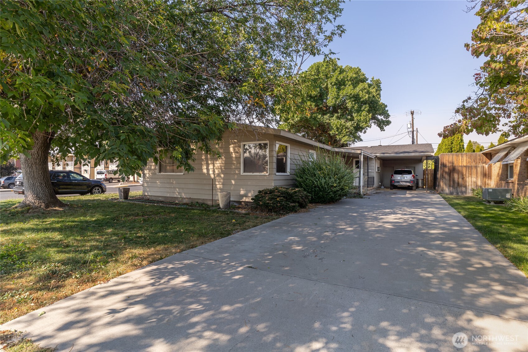 a front view of a house with a yard and trees