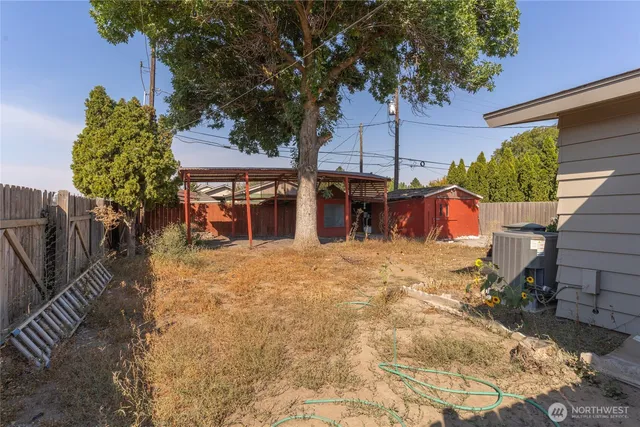 a view of a house with a yard and wooden fence