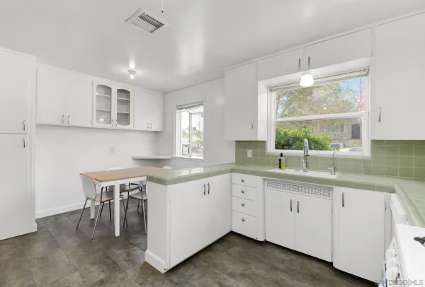 a kitchen with a sink and white cabinets