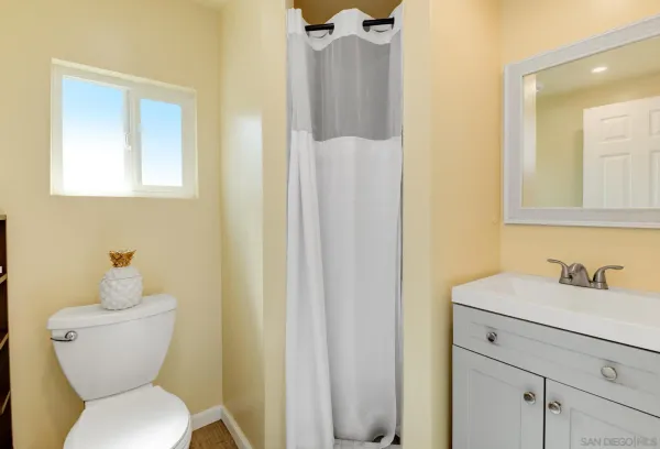 a bathroom with a toilet sink and mirror