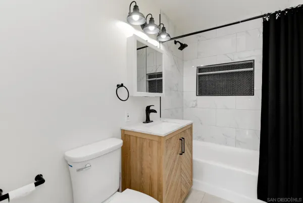 a bathroom with a sink a toilet a mirror and shower