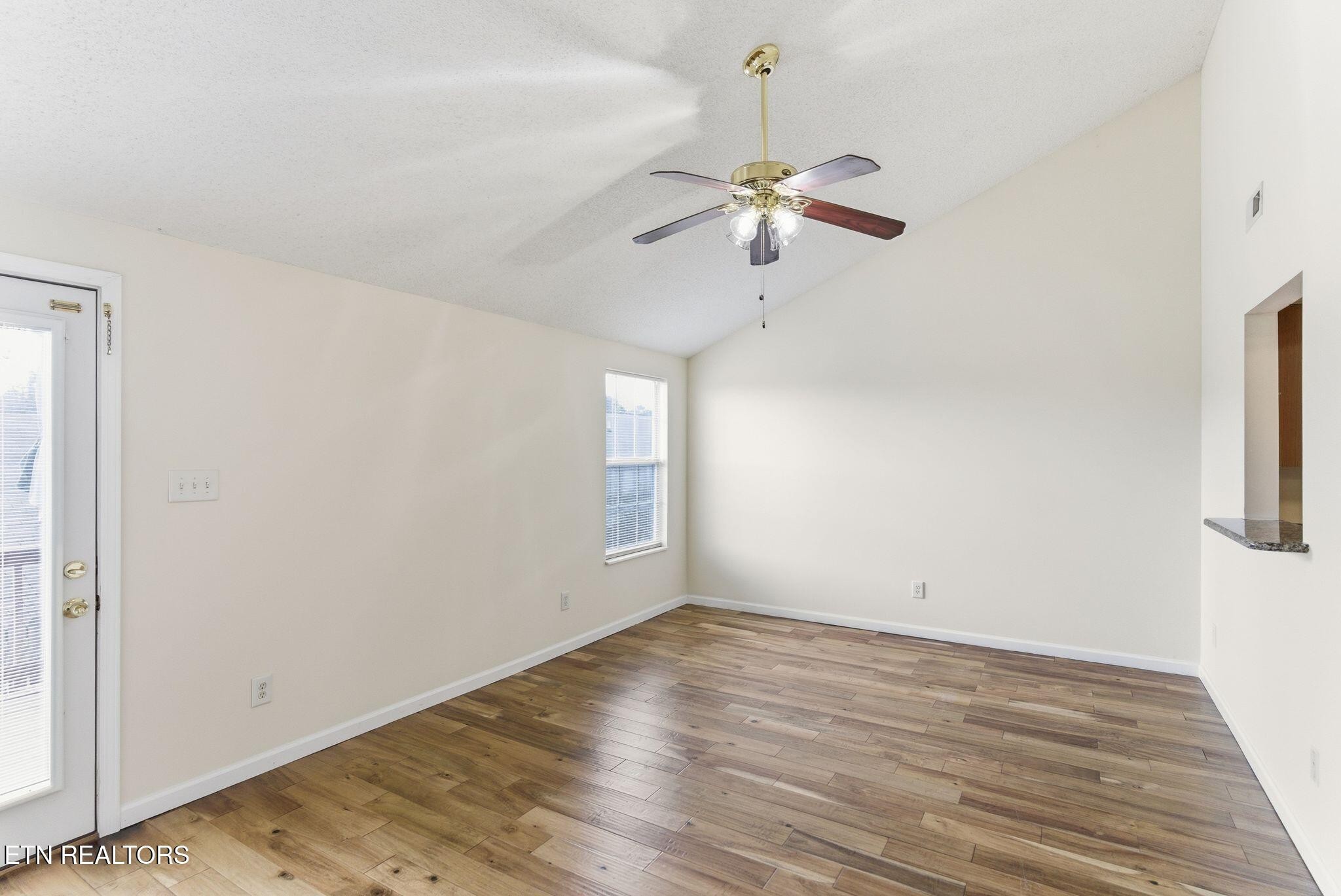 355 Hawthorne Oaks Way Powell, TN 37849 - Photo 15 of 31 an empty room with wooden floor chandelier fan and windows