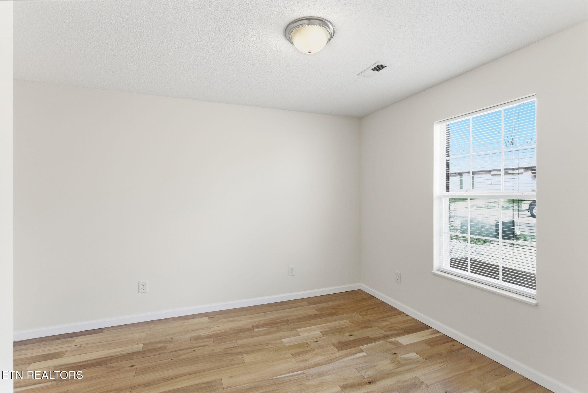355 Hawthorne Oaks Way Powell, TN 37849 - Photo 21 of 31 an empty room with wooden floor and windows