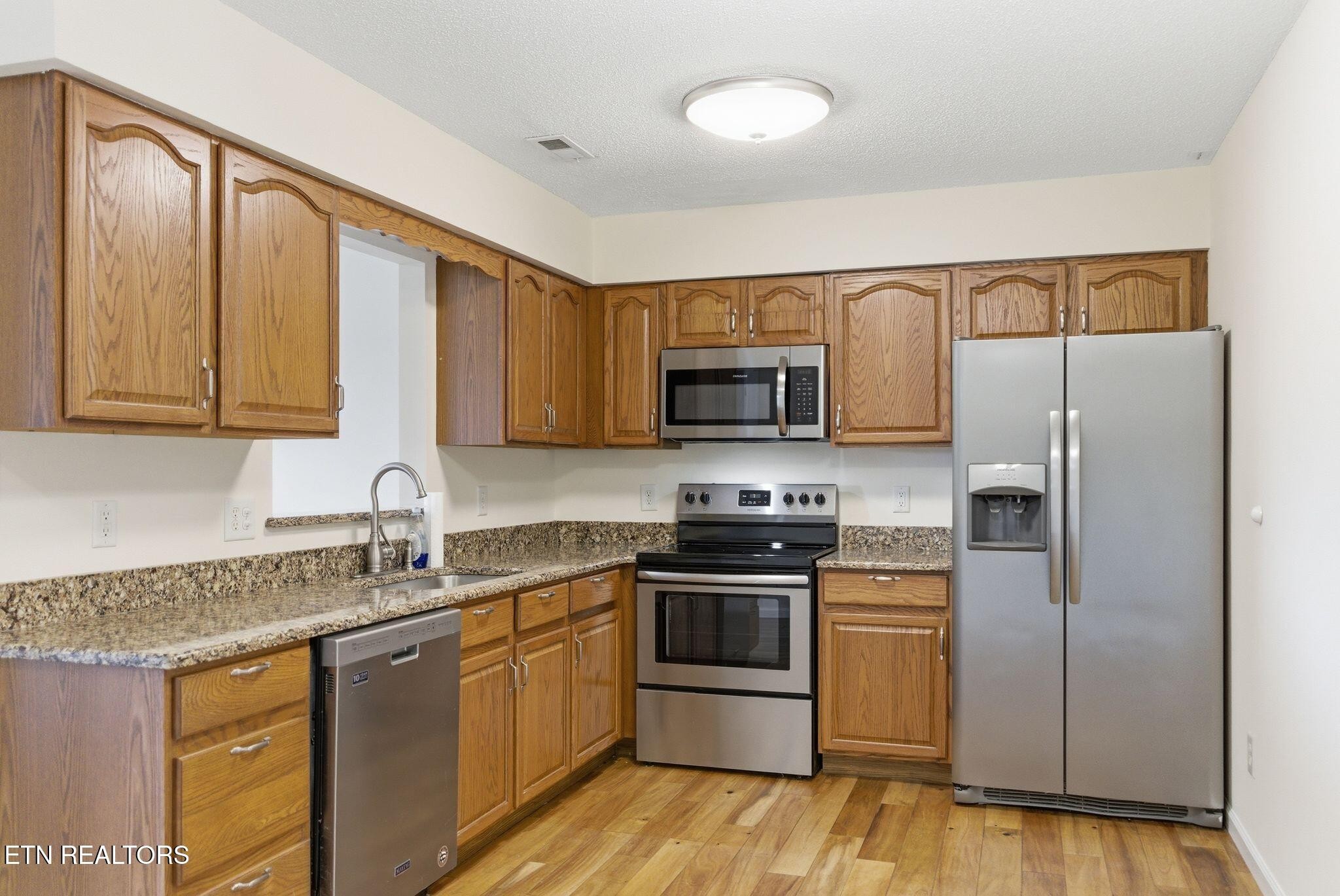 355 Hawthorne Oaks Way Powell, TN 37849 - Photo 9 of 31 a kitchen with stainless steel appliances granite countertop a refrigerator sink and stove top oven