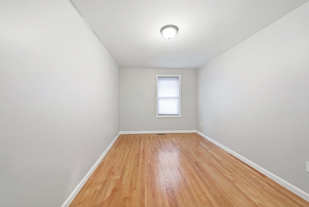 39 Hawthorne Street, Unit 39 Boston, MA 02119 - Photo 21 of 33 an empty room with wooden floor and windows