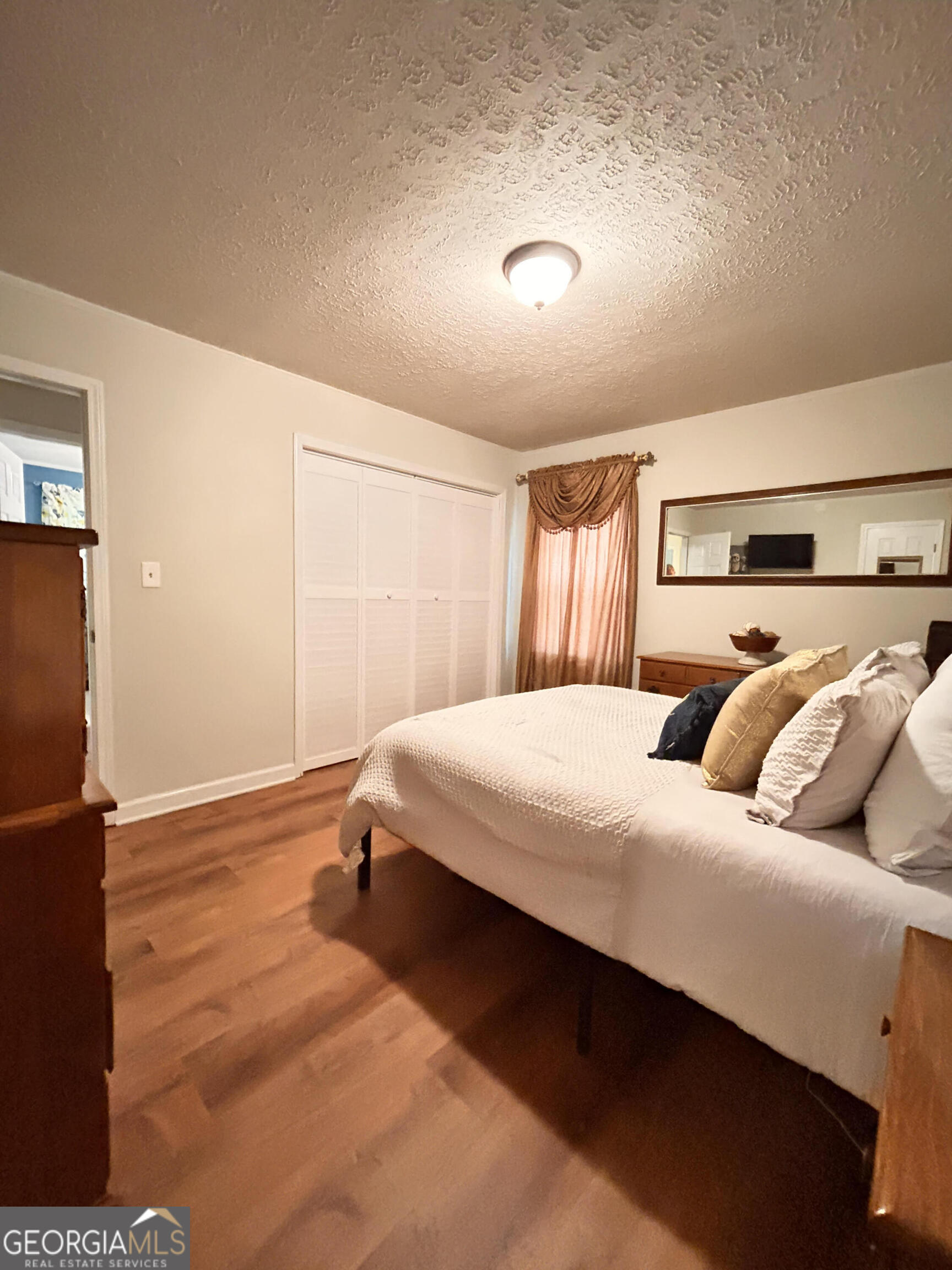 711 West Ridgeway Road Maysville, GA 30558 - Photo 16 of 38 a bedroom with a bed and wooden floor