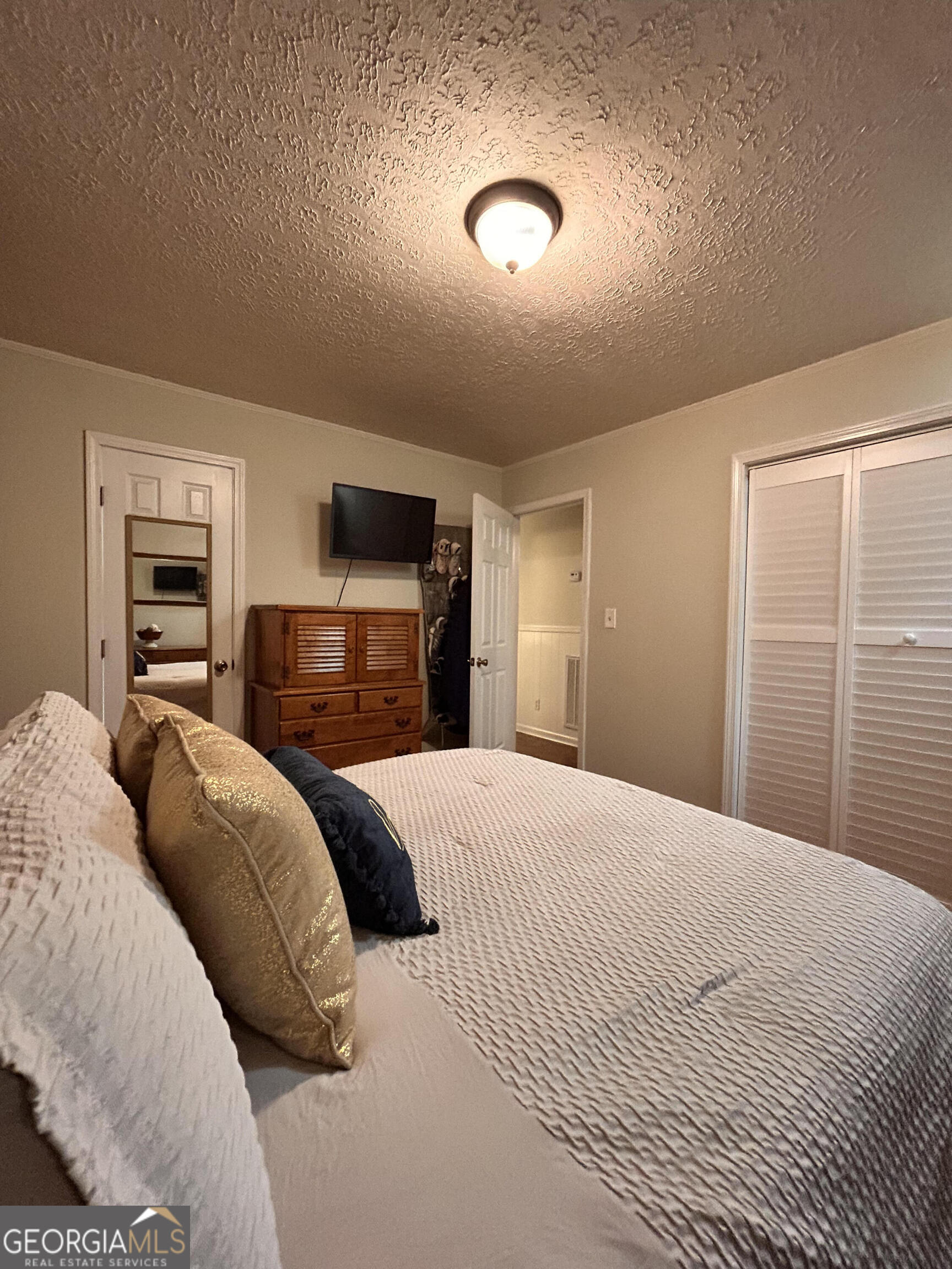 711 West Ridgeway Road Maysville, GA 30558 - Photo 18 of 38 a bedroom with a large bed and a flat tv screen