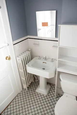 a bathroom with a sink toilet and a mirror