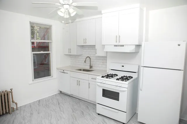 a kitchen with granite countertop white cabinets and white appliances