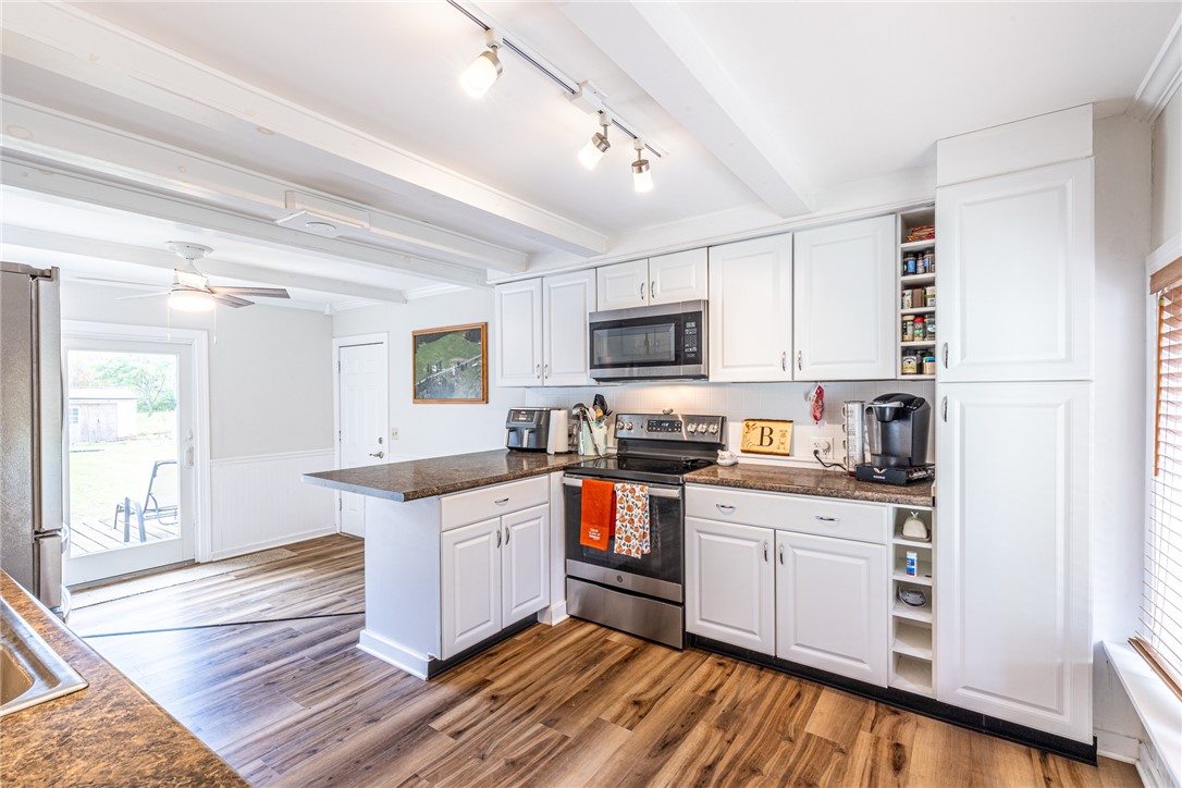6432 Lakeside Road Ontario, NY 14519 - Photo 12 of 35 Rich wood flooring anchors this well-equipped kitchen featuring beamed ceilings and recessed track lighting.