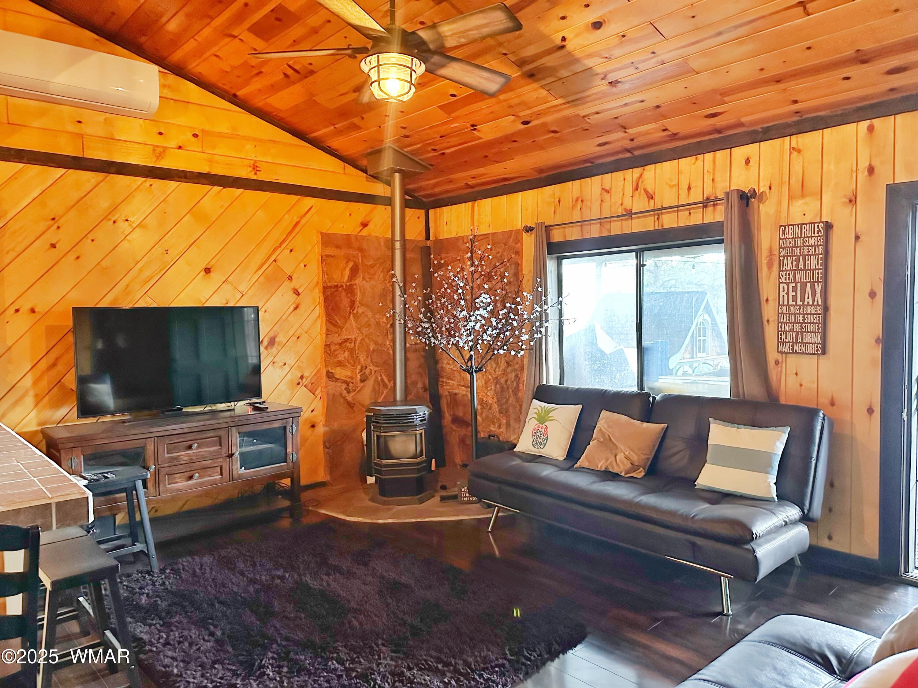 3403 Top View Road Overgaard, AZ 85933 - Photo 6 of 19 a living room with furniture a flat screen tv and a floor to ceiling window