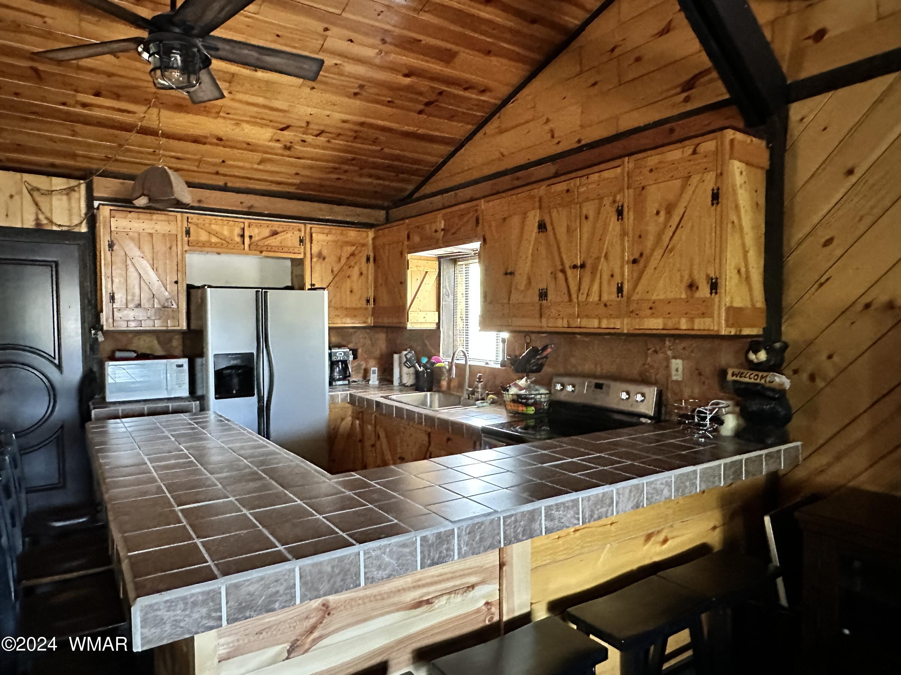 3403 Top View Road Overgaard, AZ 85933 - Photo 8 of 19 a kitchen with stainless steel appliances granite countertop a sink a stove counter space and cabinets
