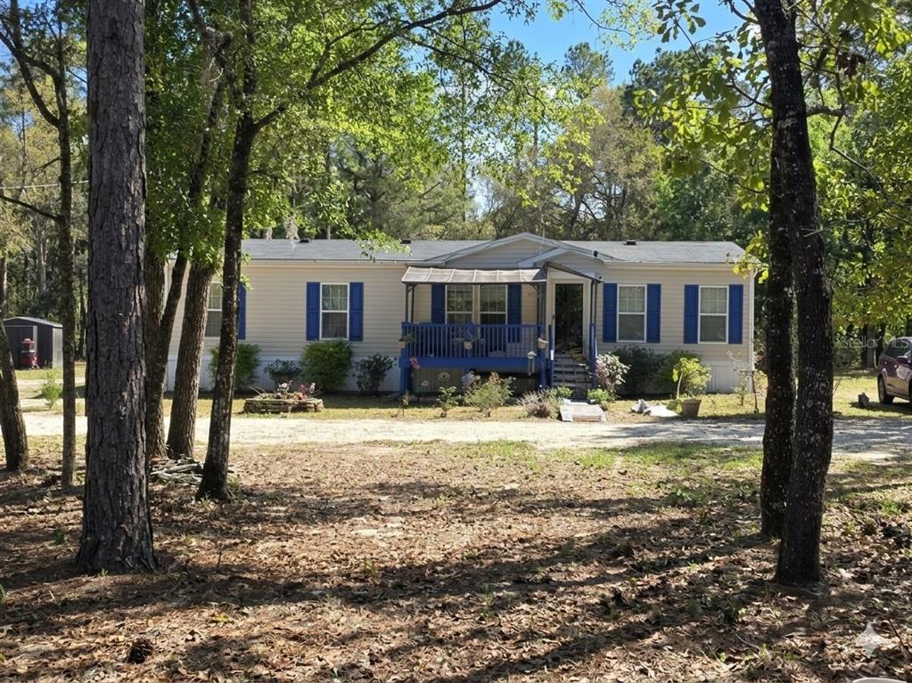 a view of a house with backyard and trees