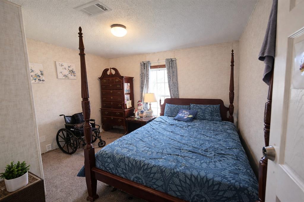 10630 Northeast 80th Street Bronson, FL 32621 - Photo 9 of 19 a bed room with a bed and a mirror