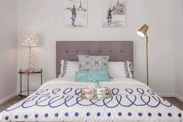 a bedroom with a large bed and a lamp