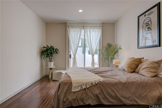a bedroom with a large bed and a potted plant
