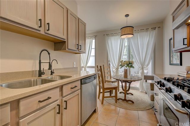 a kitchen with stainless steel appliances a sink a stove and a wooden floors