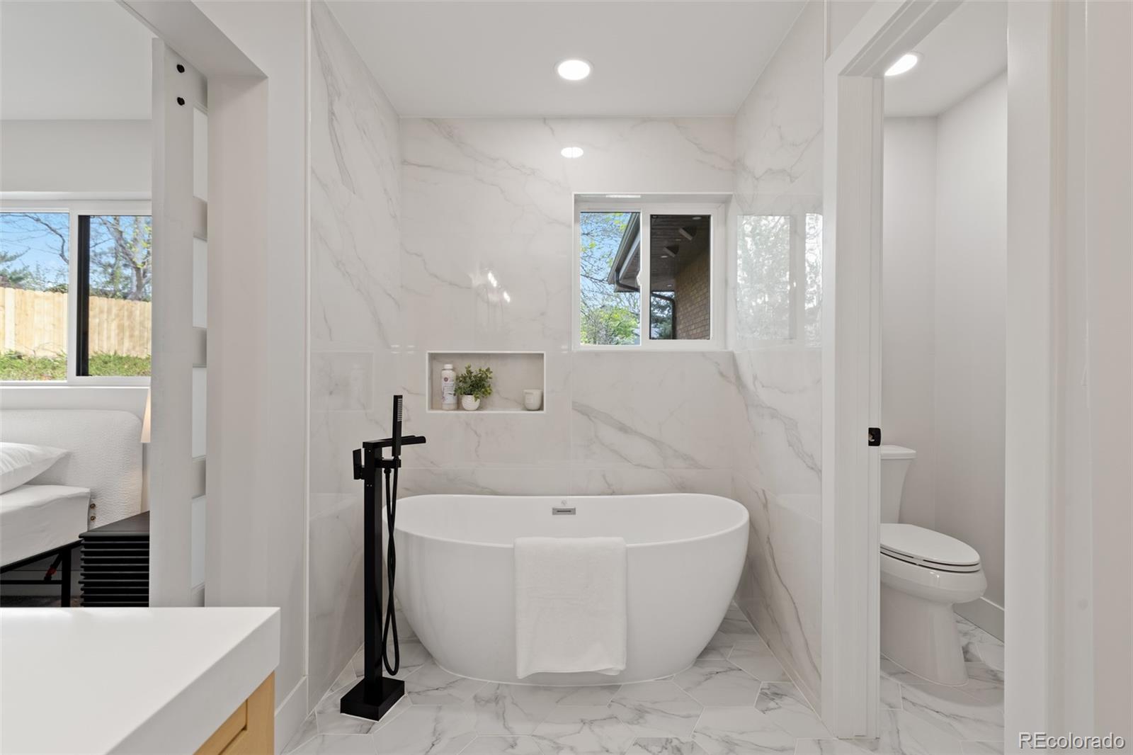 11895 West 35th Avenue Wheat Ridge, CO 80033 - Photo 26 of 50 a white bath tub sitting in a bathroom