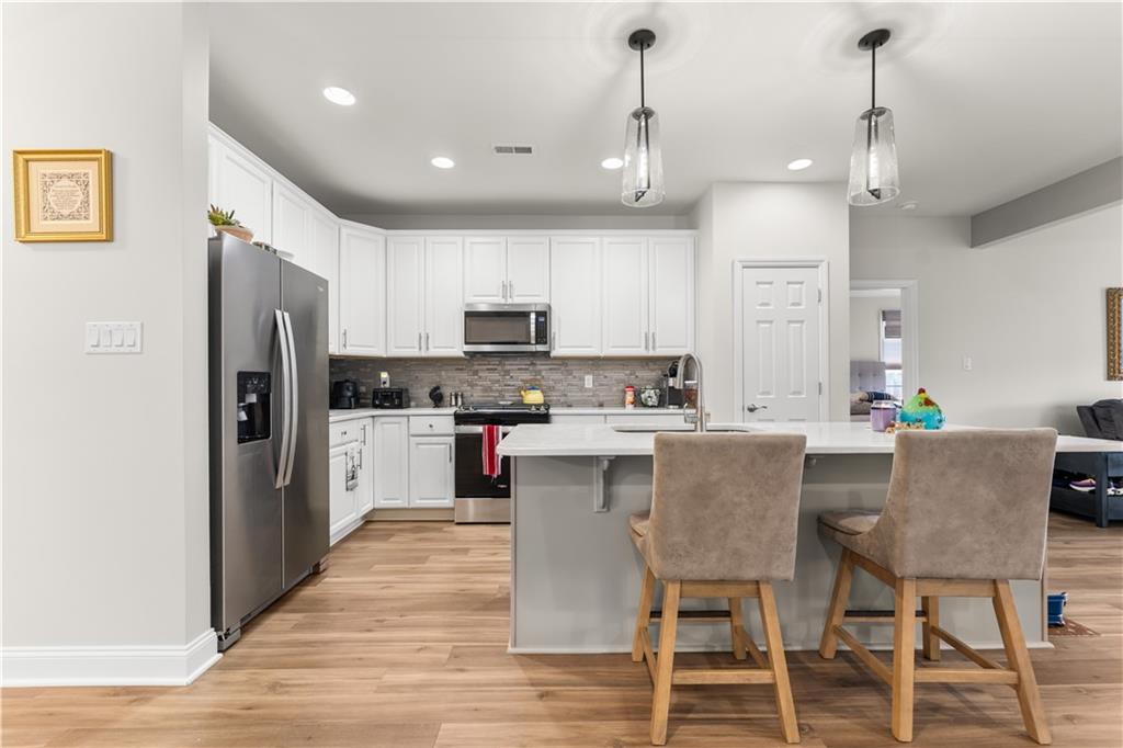 317 Anthem Way Canonsburg, PA 15317 - Photo 5 of 50 a kitchen with stainless steel appliances granite countertop a table chairs refrigerator and microwave