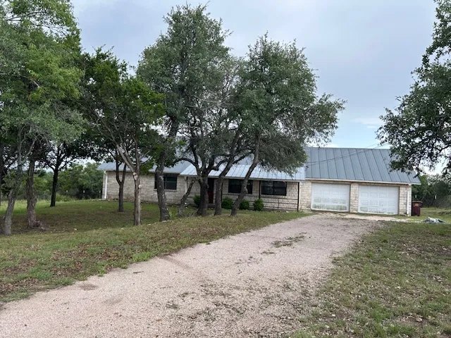 a view of a yard with a house and a large tree