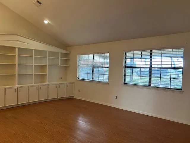 an empty room with a empty space and windows