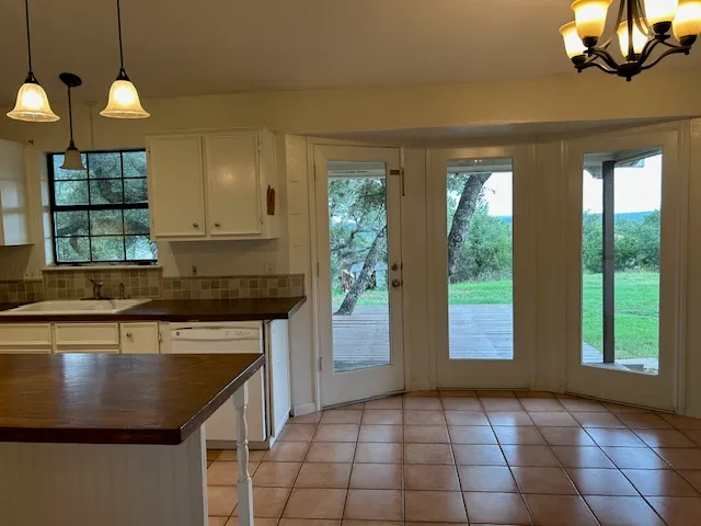 a kitchen with kitchen island granite countertop a stove a sink and a window
